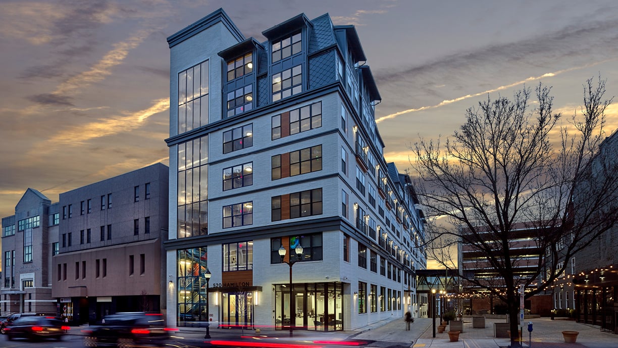 Exterior of residential and commercial building featuring Andersen 100 Series single-hung windows and gliding patio doors with sidelights