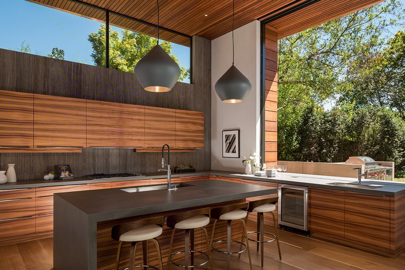 A monumental Andersen® Liftslide Pass-Through Window connects a kitchen with a patio.
