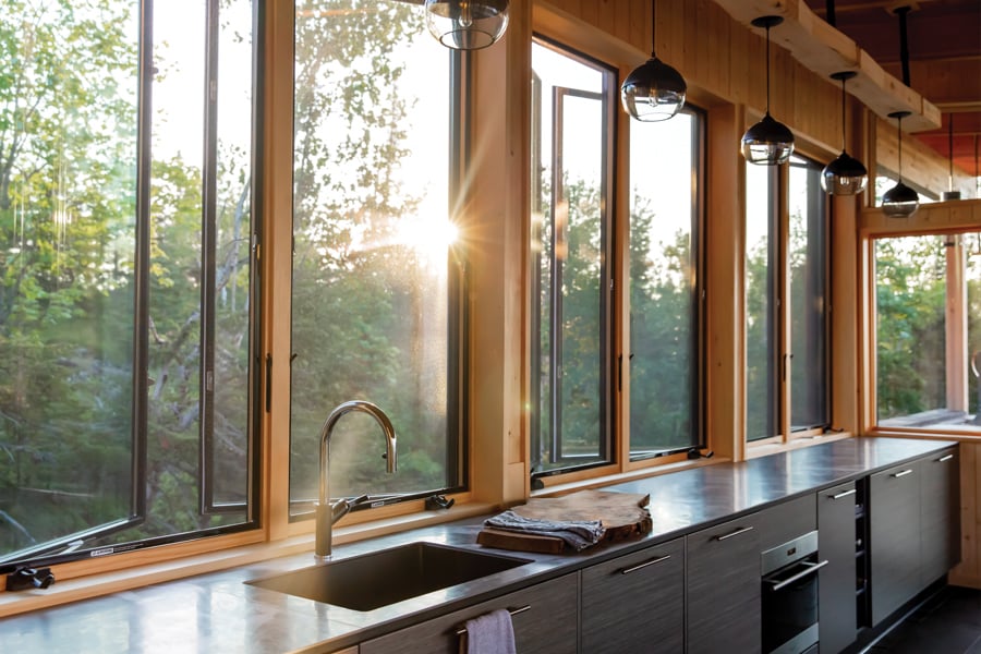 A kitchen that’s flooded with golden morning light through a row of Andersen® 400 Series Casement Windows with contemporary profiles.