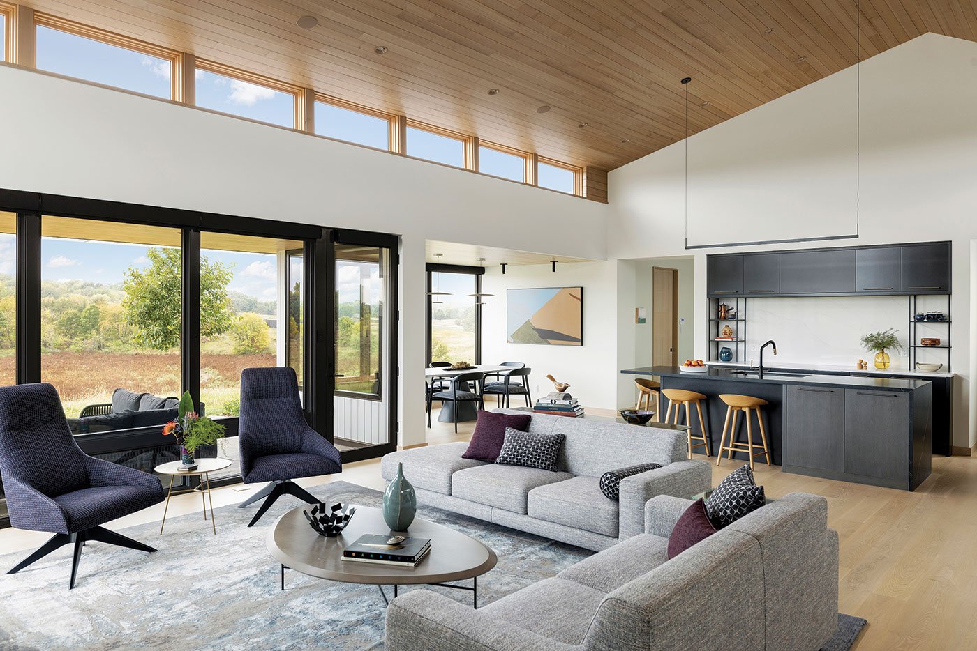 An open-concept space is flooded with natural light thanks to the floor-to-ceiling and clerestory windows.
