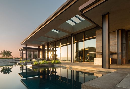 Infinity pool with wall of windows and Weiland Aluminum Wood Liftslide doors
