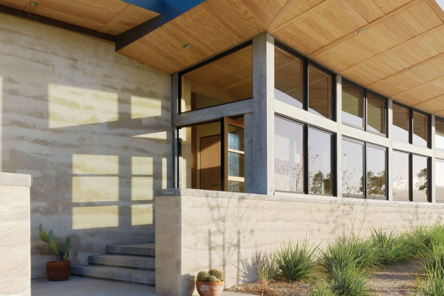 Two views of the home’s entrance, which features a Pivot Door with a clerestory window above.