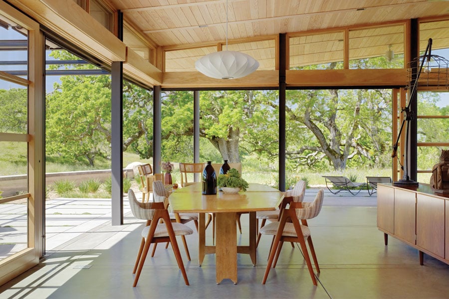 patio area with wood table and chairs under wood cover