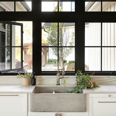 A double row of black casement windows above a kitchen sink.