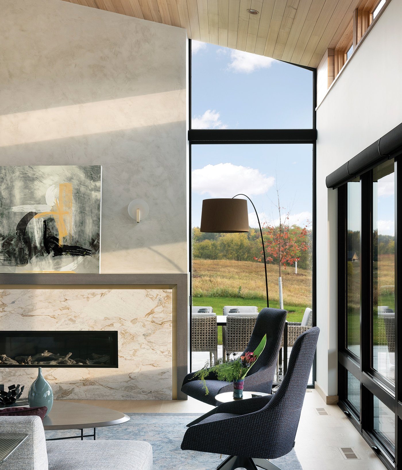 A modern home with an extra-tall floor-to-ceiling window combination made of Andersen® E-Series Picture and Specialty Windows.